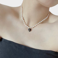 Lady wearing Luna Enamel Heart Pendant Pearl Necklace with Black heart charm